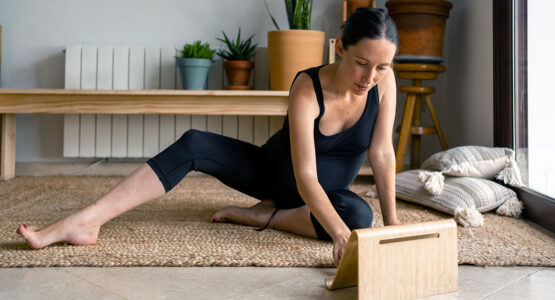 Woman doing yoga looking at a tablet